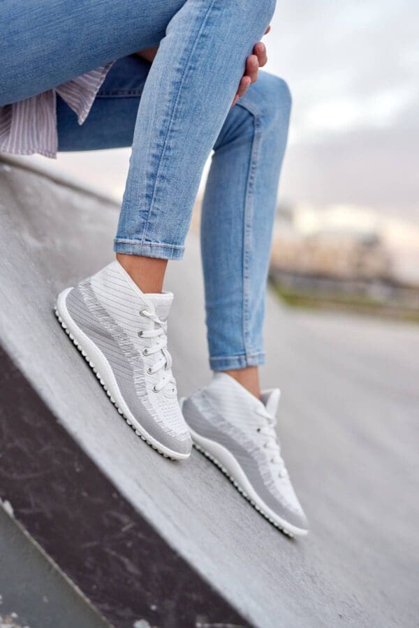 A person wearing white sneakers and jeans.