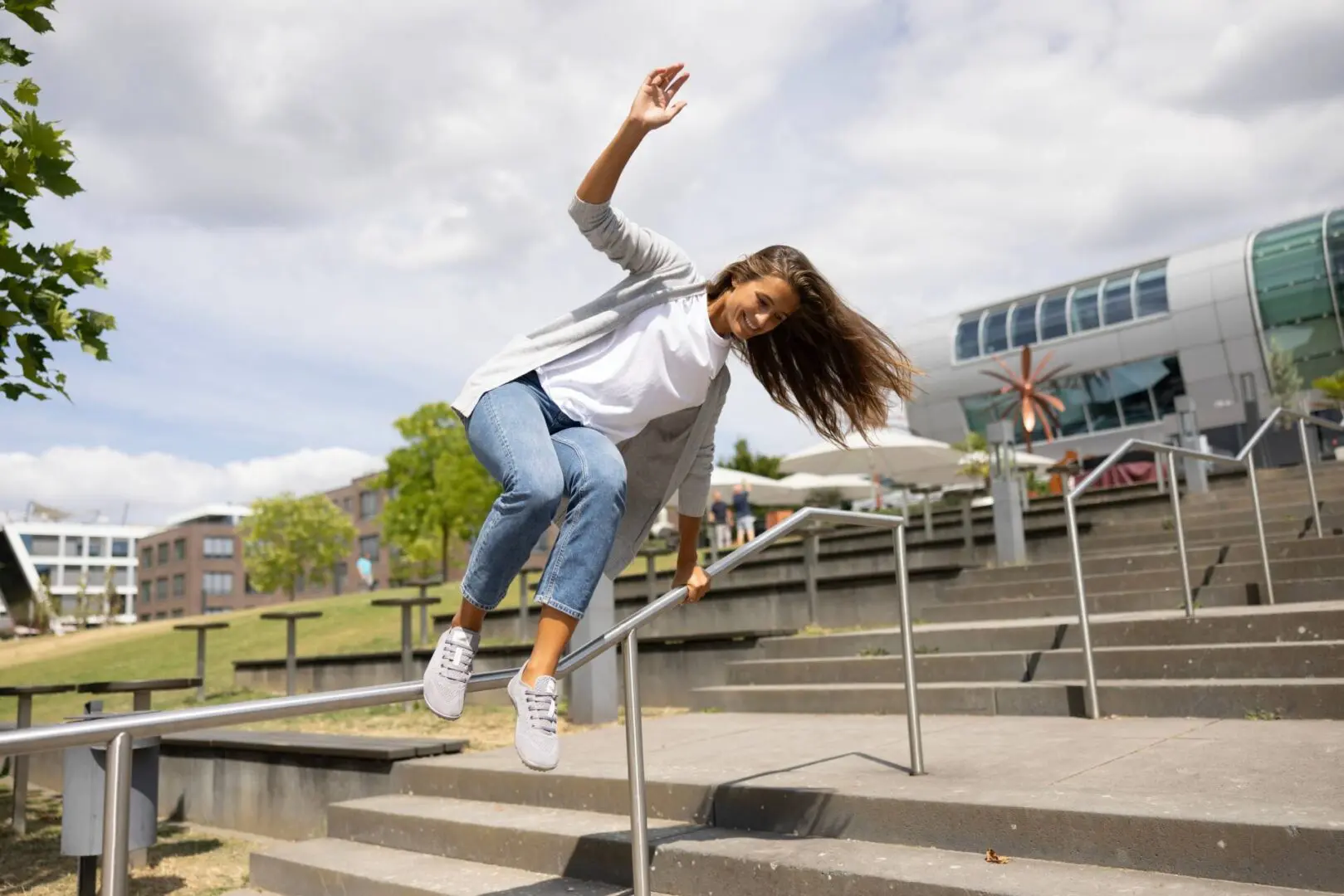 A girl is doing tricks on her skateboard.