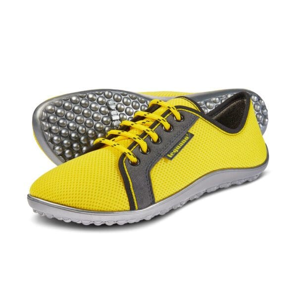 A pair of yellow and grey shoes with gray soles.