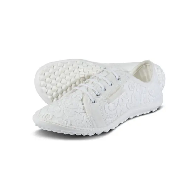 A pair of white shoes with spikes on the side.
