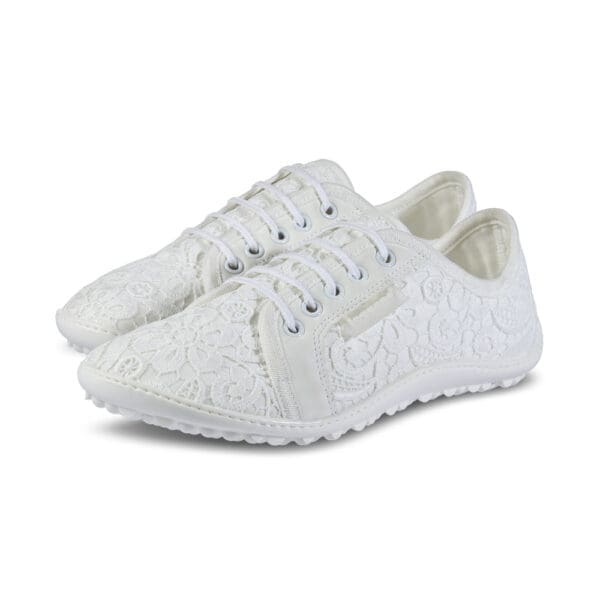 A pair of white shoes with laces on top.
