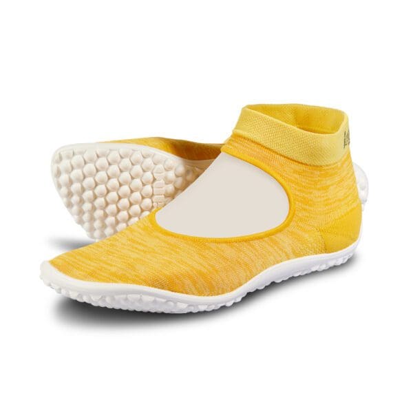 A pair of yellow shoes with white soles.