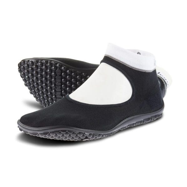 A pair of black and white shoes with a sole.