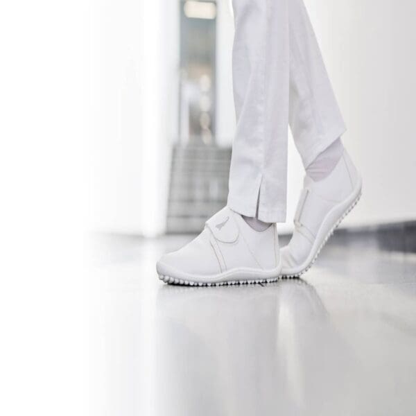 A person in white shoes standing on the floor.