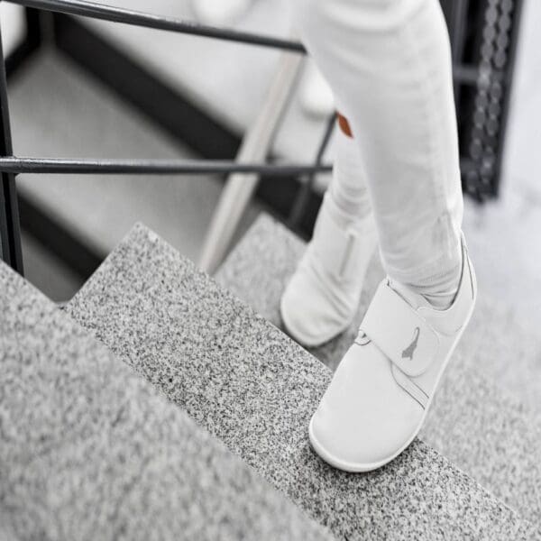 Person walking down stairs wearing white care.