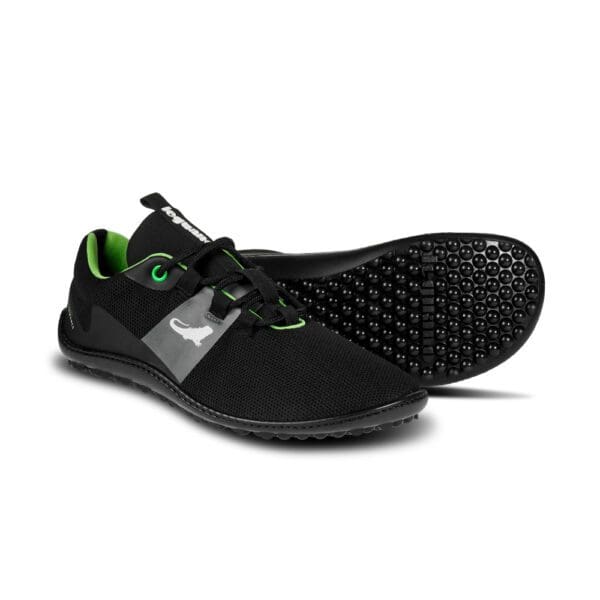 A pair of black and green shoes on top of a white background.