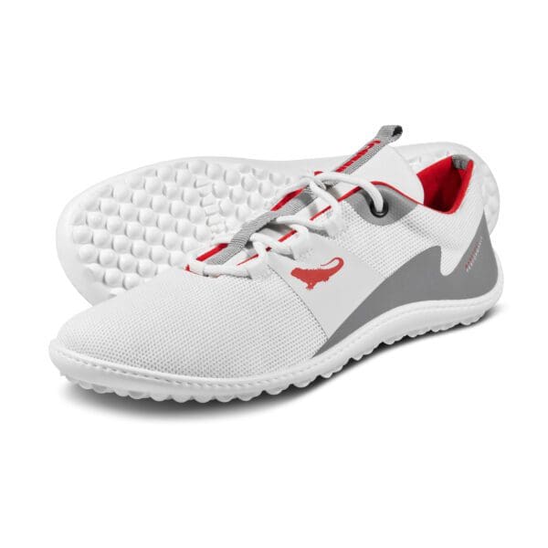 A pair of white shoes with grey and red accents.